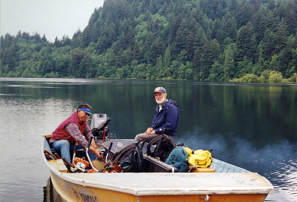Two men sit in a small motorboat within the Harrison River.