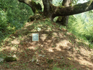 A large mound of earth is marked with a small sign.