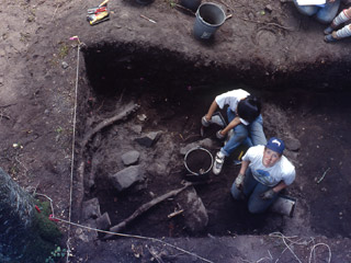 A large mound of earth is marked with a small sign.