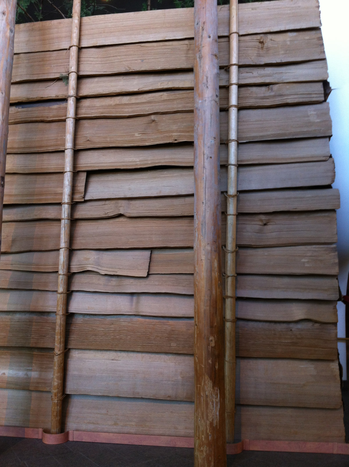 A series of overlapping horizontal wood planks held upright by small posts
