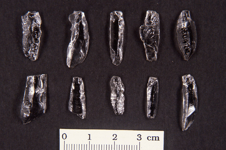 Ten small flat pieces of translucent rock of with sharp edges.