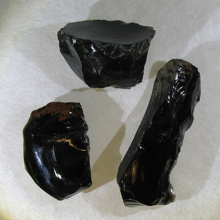 Three black and very shiny rocks.