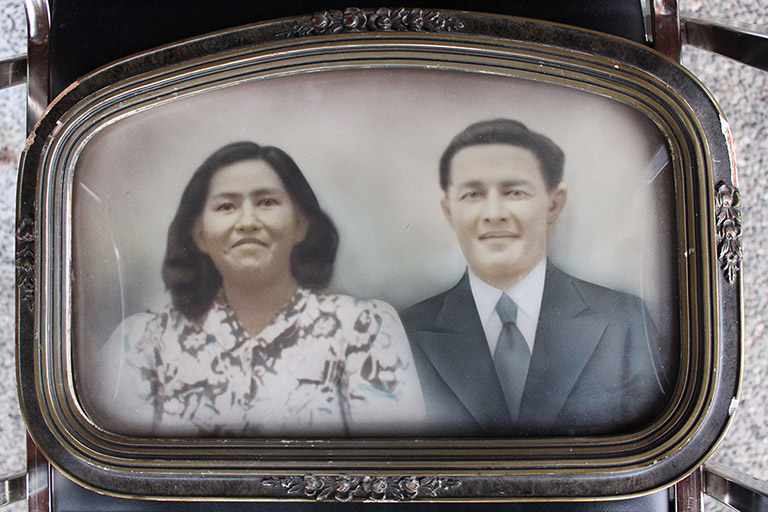 A framed photograph of a young couple. The frame is dark silver, with some ornate details on the sides.