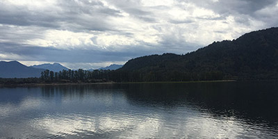 River reflecting a cloud-streaked sky.